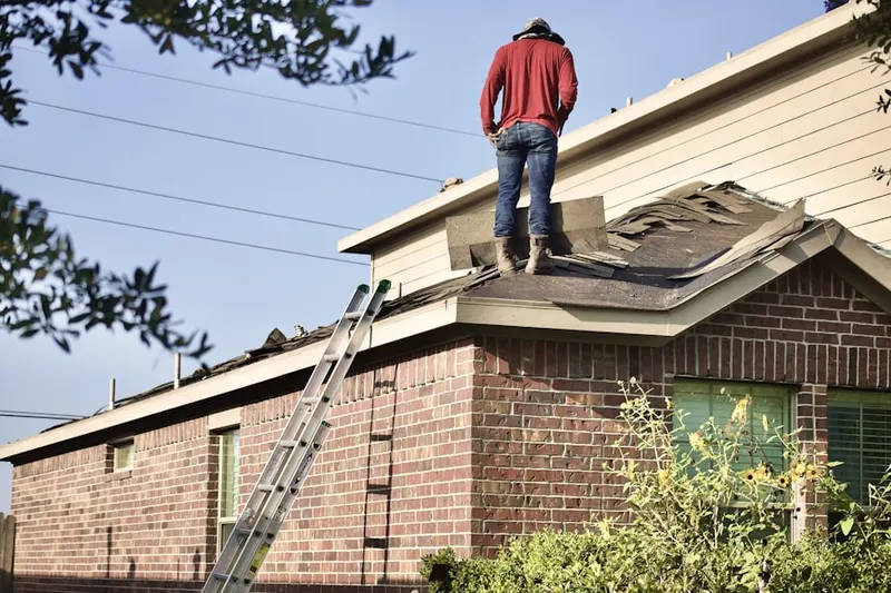 Professional roofer working on a residential roof in Marplewood Villa